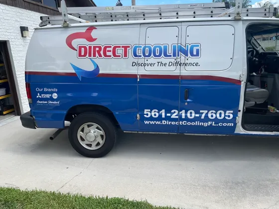Side of a Direct Cooling van showing the logo, phone number and ladder rack